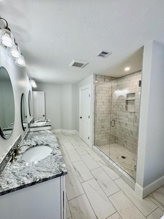 200A Randall Rd, Berlin, MA 01503 - bathroom with double vanity, a shower stall, baseboards, marble finish flooring, and a textured ceiling