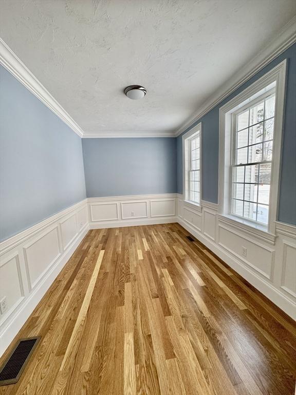200A Randall Rd, Berlin, MA 01503 - unfurnished room featuring a decorative wall, light wood-style flooring, crown molding, and wainscoting