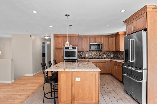 6 Myers Ln, Newbury, MA 01922 - kitchen with stainless steel appliances, light wood-type flooring, a center island, a breakfast bar area, and backsplash