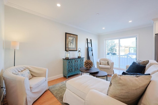 living room with ornamental molding and light hardwood / wood-style floors