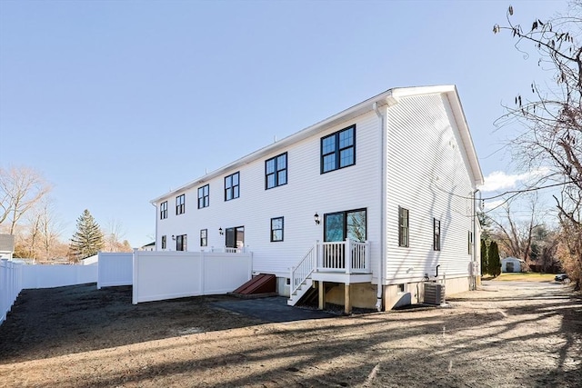 back of house with central AC unit