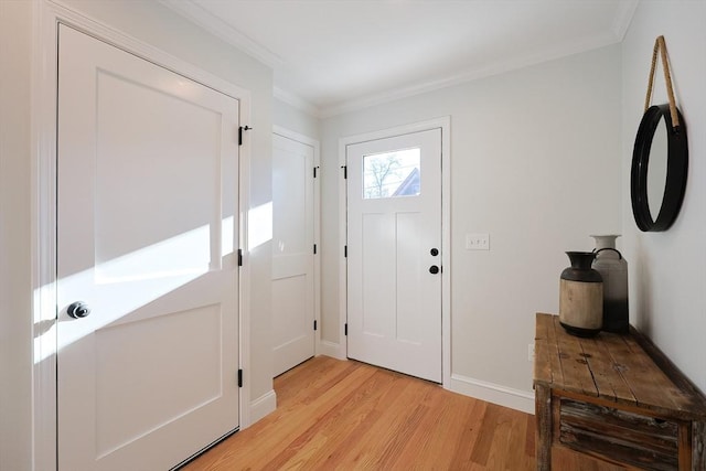 foyer entrance featuring crown molding and light hardwood / wood-style flooring