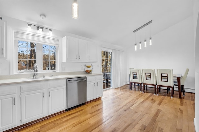 kitchen featuring sink, stainless steel dishwasher, a wealth of natural light, decorative light fixtures, and white cabinetry