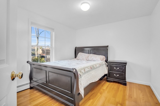 bedroom featuring hardwood / wood-style floors and a baseboard radiator