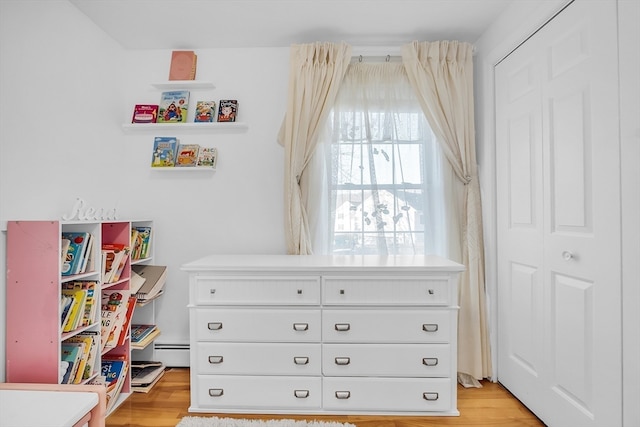 interior space featuring baseboard heating and light hardwood / wood-style flooring