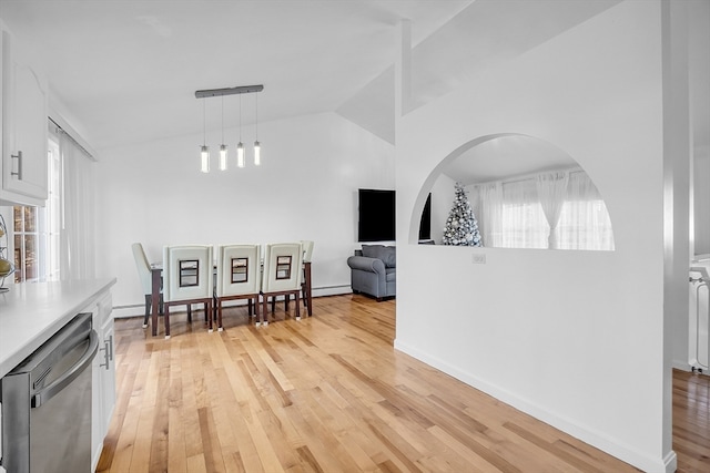 interior space with vaulted ceiling, baseboard heating, and light hardwood / wood-style flooring