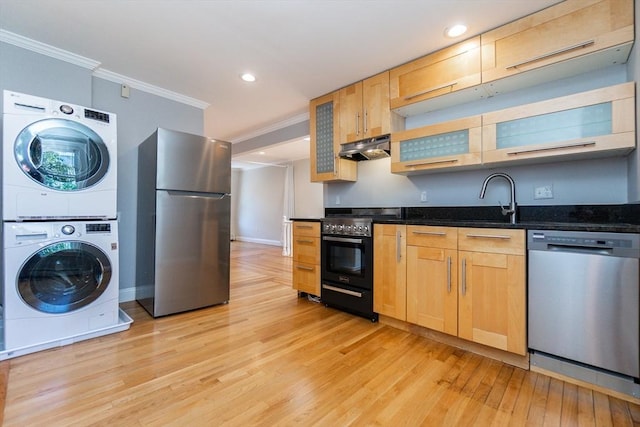 12 Springer St Unit 3, Boston, MA 02127 - kitchen with appliances with stainless steel finishes, stacked washing machine and dryer, under cabinet range hood, ornamental molding, and light wood-type flooring