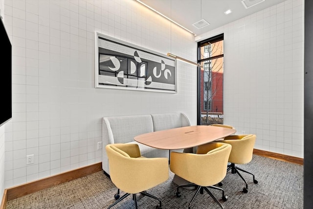 dining space with tile walls
