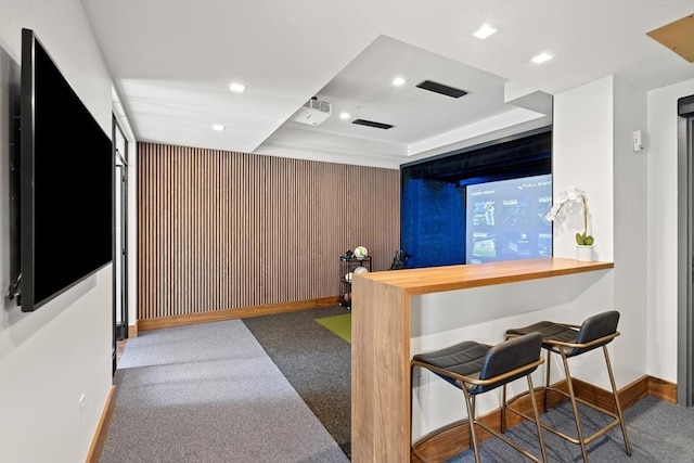 bar area with carpet floors, baseboards, recessed lighting, and a tray ceiling