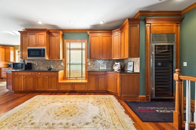 45 Joshua Rd, Wrentham, MA 02093 - kitchen with wine cooler, black microwave, stainless steel microwave, wood finished floors, and backsplash