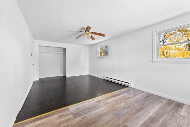 interior space featuring a closet, hardwood / wood-style floors, a baseboard radiator, and ceiling fan