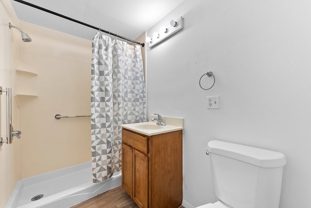 bathroom with toilet, walk in shower, hardwood / wood-style flooring, and vanity