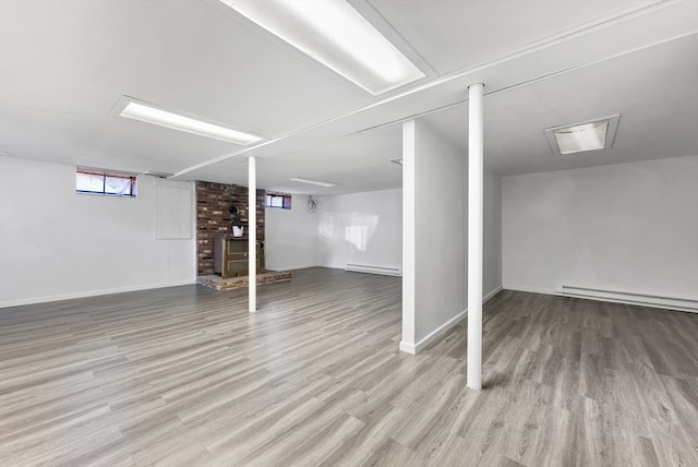 basement with a baseboard radiator and light wood-type flooring