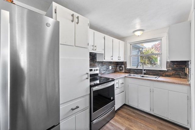 kitchen featuring stainless steel appliances, backsplash, sink, white cabinets, and dark hardwood / wood-style flooring