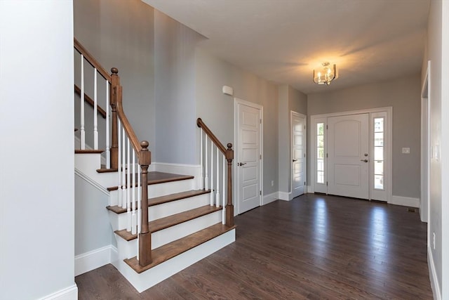 foyer entrance with dark wood-type flooring, stairway, and baseboards