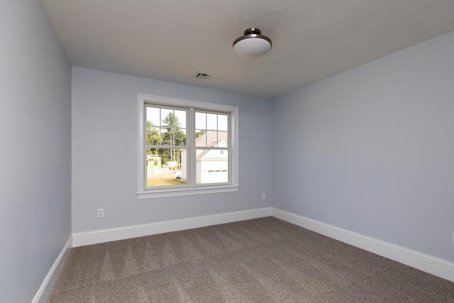 unfurnished room featuring visible vents, baseboards, and dark colored carpet