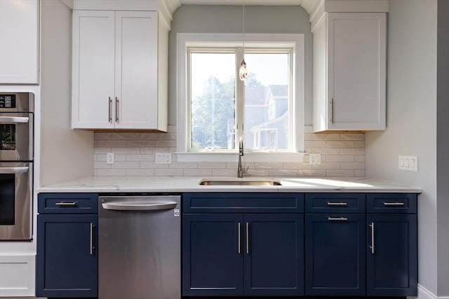 kitchen with a sink, blue cabinets, white cabinetry, and stainless steel appliances