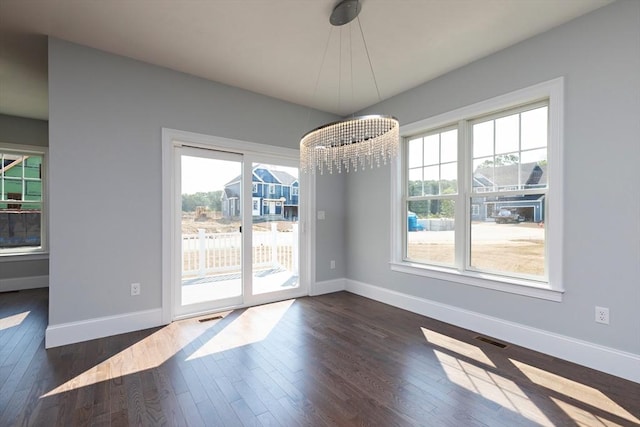 unfurnished dining area with visible vents, dark wood-style flooring, and baseboards