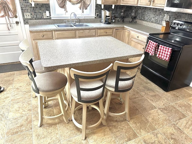 kitchen with black electric range, a kitchen breakfast bar, backsplash, and sink