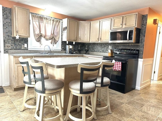 kitchen featuring black range with electric stovetop, light brown cabinets, and sink