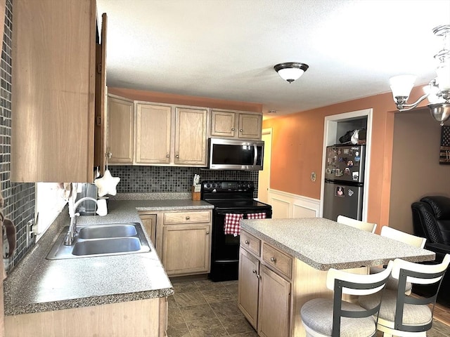 kitchen featuring decorative backsplash, appliances with stainless steel finishes, sink, light brown cabinets, and a kitchen island