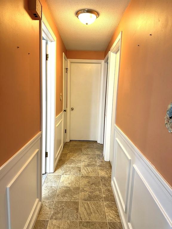 hallway with a textured ceiling