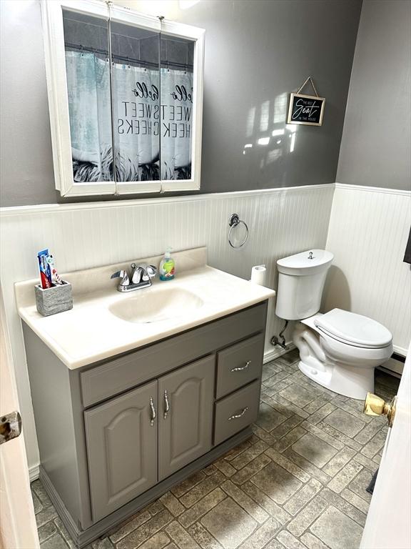 bathroom featuring a shower with curtain, vanity, and toilet