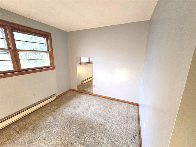 carpeted spare room with a baseboard heating unit