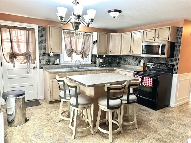 kitchen with light brown cabinets, sink, black range with electric cooktop, and an inviting chandelier