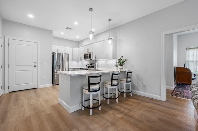 3302 Briarwood Vlg Unit 3302, Clinton, MA 01510 - kitchen featuring appliances with stainless steel finishes, a peninsula, light wood-type flooring, white cabinetry, and recessed lighting