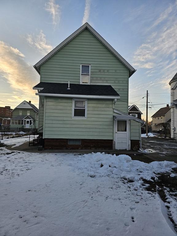 view of snow covered rear of property