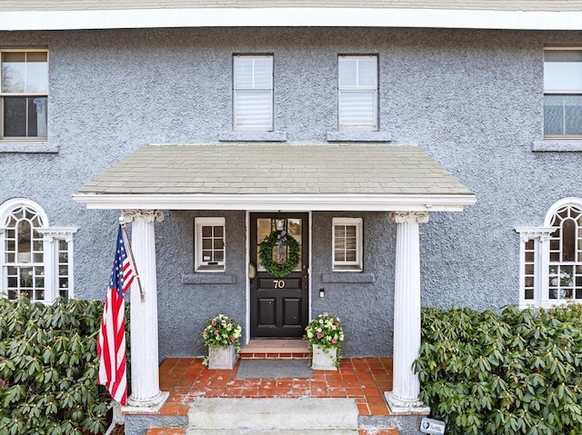 70 Hawthorn St, New Bedford, MA 02740 - view of exterior entry with stucco siding and covered porch