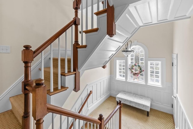 70 Hawthorn St, New Bedford, MA 02740 - staircase featuring a wainscoted wall, carpet, a decorative wall, and lofted ceiling