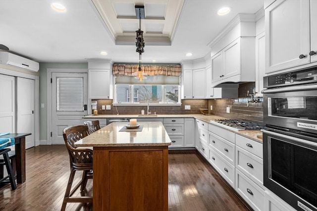 70 Hawthorn St, New Bedford, MA 02740 - kitchen with appliances with stainless steel finishes, an AC wall unit, a sink, a kitchen breakfast bar, and dark wood finished floors