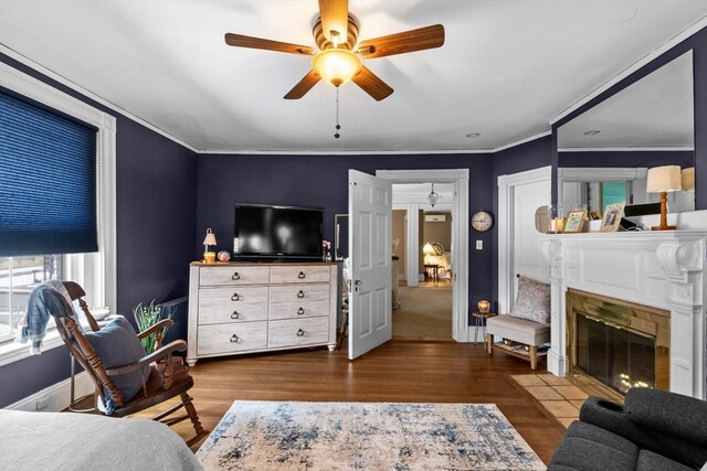 70 Hawthorn St, New Bedford, MA 02740 - bedroom featuring wood finished floors, ornamental molding, a fireplace with flush hearth, ceiling fan, and baseboards