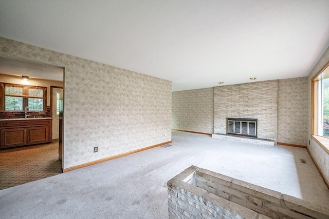 136 Butternut Hollow Rd, West Springfield, MA 01089 - unfurnished living room with light carpet, plenty of natural light, a fireplace, and a sink