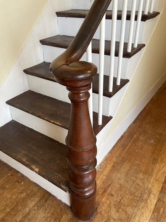 stairs with wood finished floors and baseboards