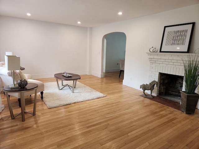 52 Walnut St, Shrewsbury, MA 01545 - living area with arched walkways, light wood-style floors, recessed lighting, a brick fireplace, and baseboards