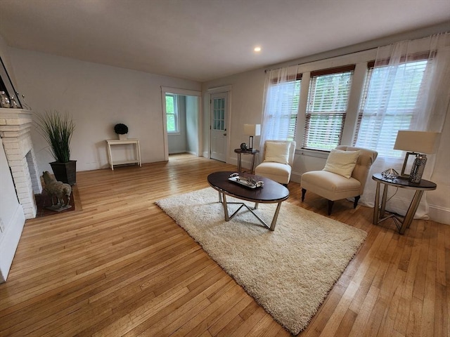 52 Walnut St, Shrewsbury, MA 01545 - living room with light wood-type flooring, a brick fireplace, recessed lighting, and baseboards