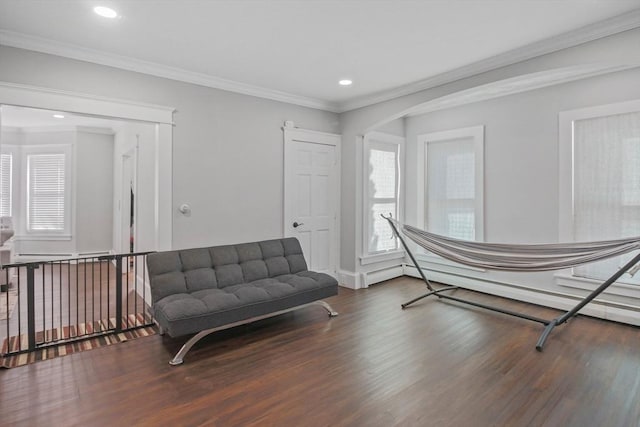 living area with ornamental molding and dark wood-type flooring