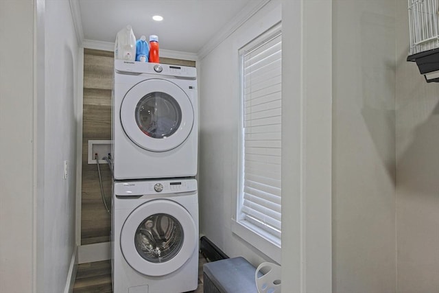 washroom with hardwood / wood-style floors, crown molding, and stacked washing maching and dryer