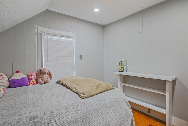 bedroom featuring hardwood / wood-style flooring and vaulted ceiling