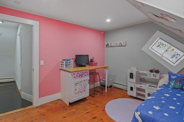 bedroom featuring light hardwood / wood-style floors and a baseboard heating unit