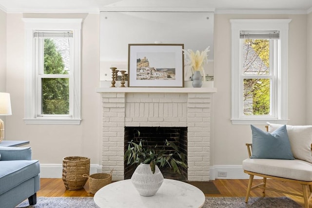 living room with ornamental molding, wood finished floors, a healthy amount of sunlight, and a fireplace