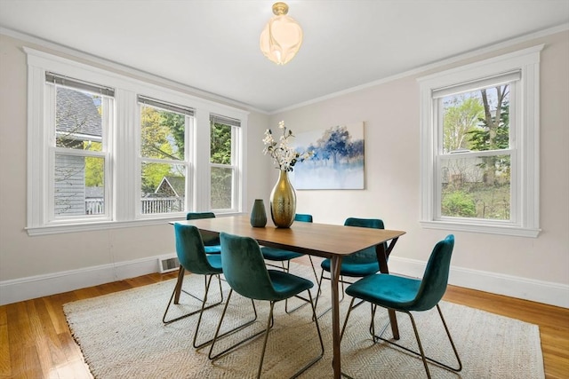 dining space with baseboards, crown molding, plenty of natural light, and visible vents