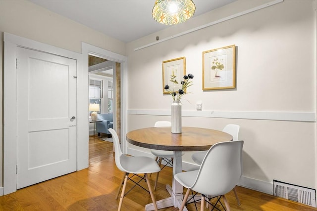 dining space with visible vents, baseboards, and light wood-type flooring
