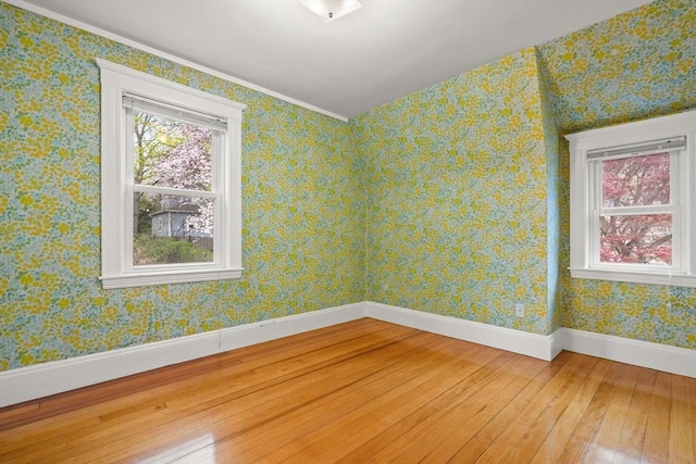 unfurnished room with baseboards and hardwood / wood-style flooring