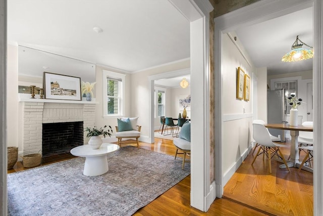 living area with baseboards, a fireplace, and wood finished floors