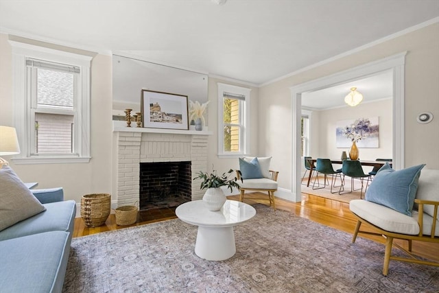 living room with ornamental molding, a brick fireplace, and wood finished floors