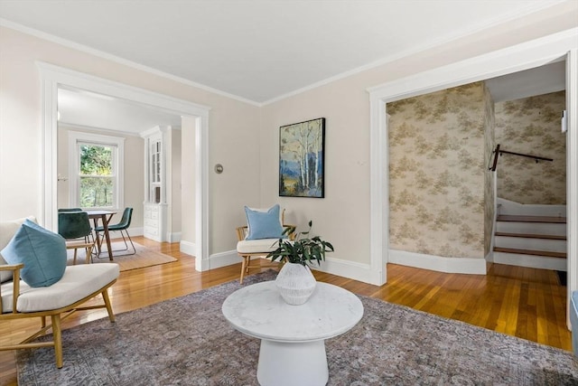 living area with stairway, baseboards, ornamental molding, and wood finished floors